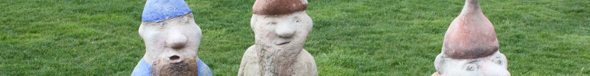 Drei Zwerge aus Beton auf Rasen